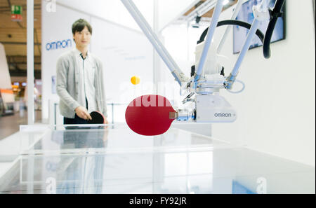 Hannover, Germania. 23 apr, 2016. Un uomo giocando a ping pong con un robot allo stand di Omron alla fiera di Hannover di Hannover, Germania, 23 aprile 2016. Di tutto il mondo più grande fiera industriale a Hannover Messe è di essere aperti dal US-Presidente Obama il 24 aprile. Gli Stati Uniti d'America sono quest anno il paese di partnership. Foto: JULIAN STRATENSCHULTE/dpa/Alamy Live News Foto Stock