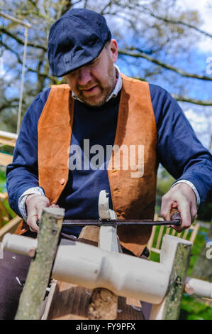 Un artigiano del legno utilizza un spokeshave (disegnare piano) a circa attorno a un pezzo di legno. Foto Stock