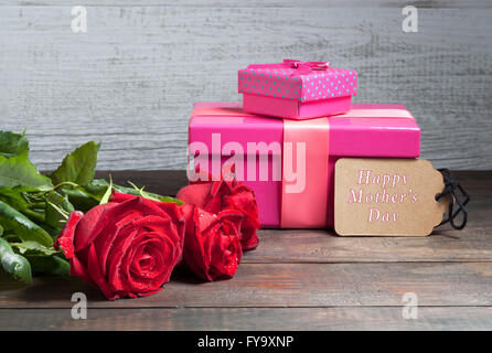 Felice Festa della Mamma testo con rose rosse e rosa confezioni regalo sul tavolo di legno Foto Stock