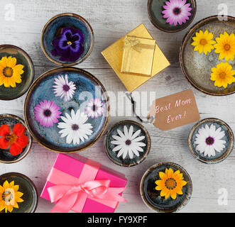 Best Mom mai!!! Testo con fiori e confezioni regalo su un tavolo di legno. Vista dall'alto. Foto Stock