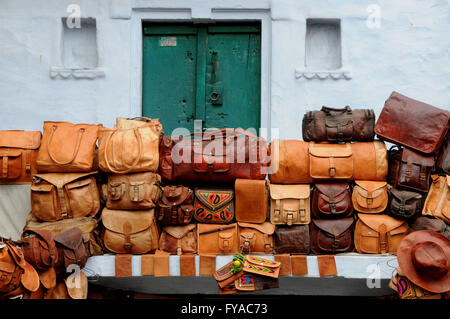 Colorata borse in pelle per la vendita su uno stallo nella città di Rajasthani di Udaipur in India del nord. Foto Stock