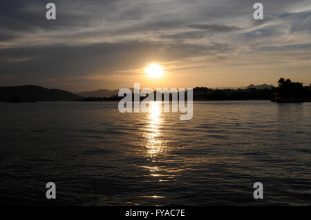 Tramonto sul lago Pichola in cui sorge la città di Udaipur nel Rajasthan, India settentrionale. Foto Stock