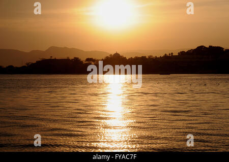 Tramonto sul lago Pichola in cui sorge la città di Udaipur nel Rajasthan, India settentrionale. Foto Stock