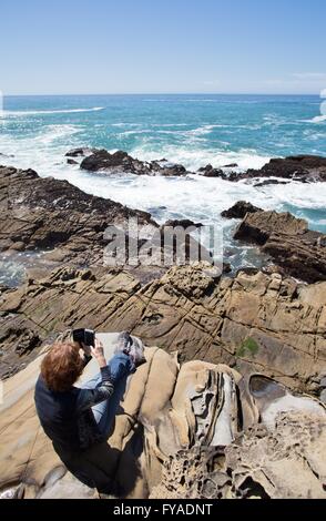 Una donna di scattare una foto dell'Oceano Pacifico con un telefono cellulare. Foto Stock