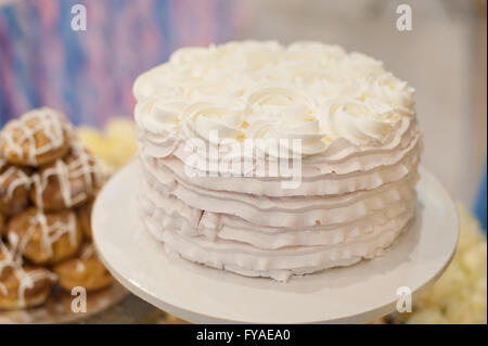 Torta decorata con rose sul tavolo Foto Stock