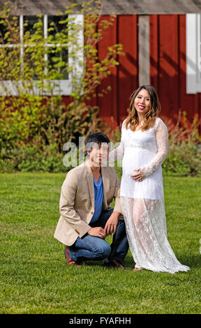 Aspettano di mamma e papà, sia guardando in avanti alla fotocamera, godendo la giornata all'aperto. Foto Stock