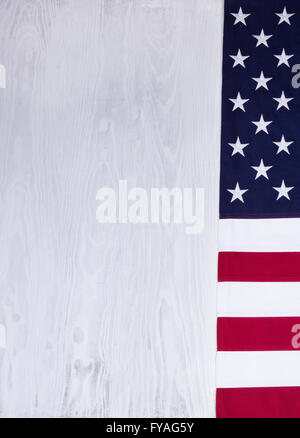 Panno piegato bandiera, bordo destro di Stati Uniti d'America su legno bianco nel formato verticale. Foto Stock