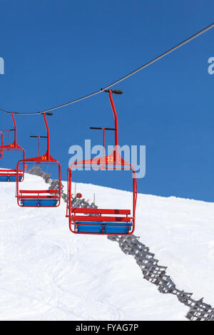 Svuotare quattro sedie di ski lift scendendo dalla vetta della montagna Foto Stock