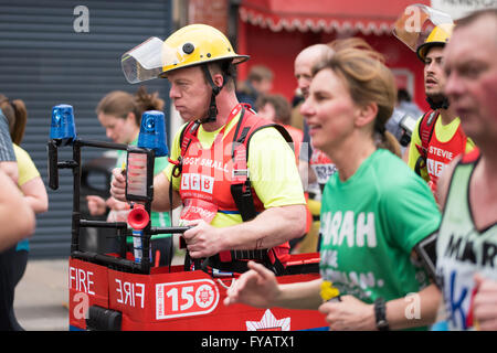 Londra - 24 aprile 2016. La maratona di Londra. I vigili del fuoco tentativo record mondiale di maratona più veloce in un quattro-persona costume. Foto Stock