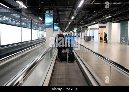 KLM equipaggio di cabina al tapis roulant in aeroporto Schiphol di Amsterdam Paesi Bassi Foto Stock