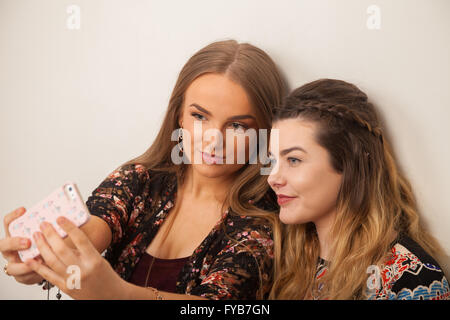 Due ragazze adolescenti prendendo un selfie degli stessi. Foto Stock