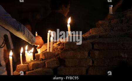 Kathmandu, Nepal. 24 apr, 2016. Un partecipante accende una candela nel le rovine del tempio Kasthamandap durante la veglia a lume di candela organizzato in memoria delle vittime delle anime durante il forte terremoto che ha colpito lo scorso anno a Hanumandhoka Durbar Square. Credito: Archana Shrestha che Pacifico/press/Alamy Live News Foto Stock