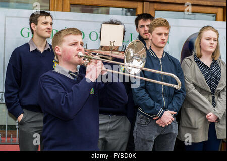 Skibbereen, Irlanda. 24 Aprile, 2016. Attuali ed ex alunni stand silenziosamente come Eoin Leahy riproduce gli ultimi post il trombone durante la misericordia altezze della scuola Annuncio evento della durata di un giorno per commemorare i 100 anni dall'inizio della ribellione in Dublino. Credito: Andy Gibson/Alamy Live News Foto Stock
