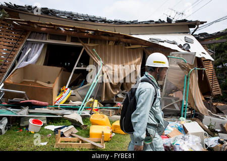 KUMAMOTO, Giappone - 22 aprile: un terremoto superstite è visto attraverso il relitto di case su Aprile 22, 2016 in città Mashiki, Kumamoto, Giappone. Una serie di terremoti grandi come grandezza 7.3 hit Prefettura di Kumamoto lasciando 48 morti e 263 feriti gravi. Oltre 80.000 persone sono state evacuate dalle loro case come un risultato. ( Foto da Richard Atrero de Guzman/AFLO) Foto Stock