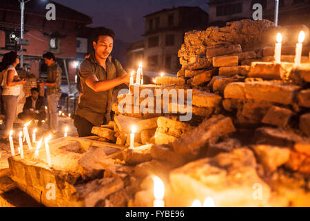 Il quadrato di Durbar di Kathmandu, Nepal. Il 24 aprile 2016. Luci uomo candel in memoria dei morti come la folla si riuniscono alla vigilia dell'anniversario eathquke. Credito: Alice Carfrae/Alamy Live News Foto Stock