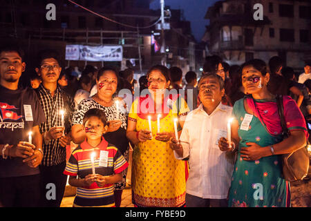 Il quadrato di Durbar di Kathmandu, Nepal. Il 24 aprile 2016. Una famiglia detiene candele in memoria dei morti come la folla si riuniscono alla vigilia dell'anniversario eathquke. Credito: Alice Carfrae/Alamy Live News Foto Stock