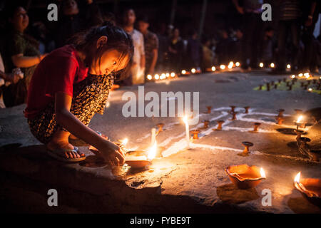 Il quadrato di Durbar di Kathmandu, Nepal. Il 24 aprile 2016. Una ragazza luci candele in memoria dei morti come la folla si riuniscono alla vigilia dell'anniversario eathquke. Credito: Alice Carfrae/Alamy Live News Foto Stock