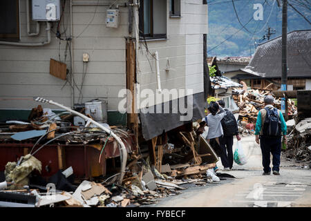 KUMAMOTO, Giappone - 22 aprile: un terremoto superstite è visto attraverso il relitto di case su Aprile 22, 2016 in città Mashiki, Kumamoto, Giappone. Una serie di terremoti grandi come grandezza 7.3 hit Prefettura di Kumamoto lasciando 48 morti e 263 feriti gravi. Oltre 80.000 persone sono state evacuate dalle loro case come un risultato. ( Foto da Richard Atrero de Guzman/AFLO) Foto Stock