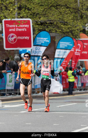 I concorrenti nella maratona di Londra in esecuzione attraverso il Canary Wharf station wagon, Londra Foto Stock