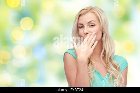 Sorridente giovane donna o ragazza teen bocca di copertura Foto Stock