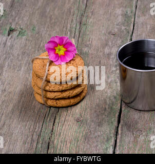 Il collegamento di fiocchi d'avena cookies decorata con un fiore su una tavola di legno Foto Stock