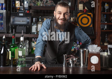 Barman al lavoro guardando la fotocamera. Foto Stock