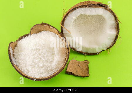 Polvere di noce di cocco in guscio di noce di cocco e cocco fresco su sfondo verde Foto Stock