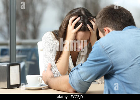 Voce maschile confortante per un triste premuto femmina che ha bisogno di aiuto in una caffetteria. Rompere o migliore amico concetto Foto Stock