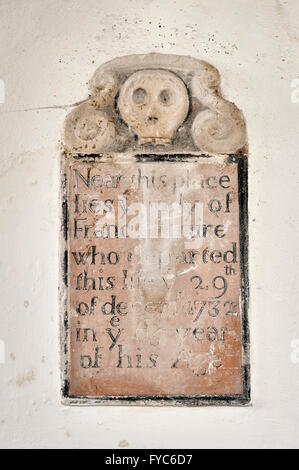 Santa Maria Maddalena, Caldecote, UK, una ridondante 14c chiesa. Un 18c memorial con cranio carving Foto Stock