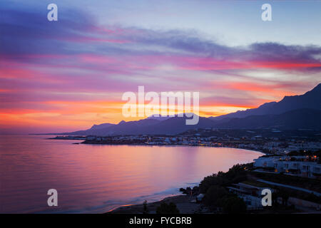 Immagine di un tramonto colorato sopra il villaggio di Makrigialos a Creta in Grecia. Foto Stock
