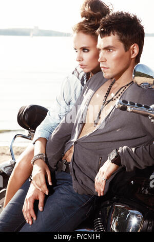 Romantico coppia giovane in abiti casual seduto su una motocicletta. Foto Stock