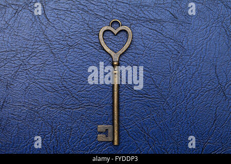 A forma di cuore chiave vintage su un sfondo di cuoio Foto Stock