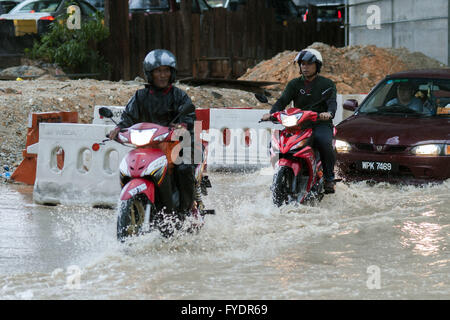 Kuala Lumpur, Malesia. 26 apr, 2016. I residenti locali guidare motocicli sulle strade allagate a causa delle pesanti piogge di Kuala Lumpur in Malesia, 26 aprile 2016. Credito: Chong Voon Chung/Xinhua/Alamy Live News Foto Stock