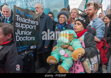 Londra, Regno Unito. Il 26 aprile, 2016. Leader laburista Jeremy Corbyn e cancelliere ombra John McDonnell nella parte anteriore del marzo da .medici e insegnanti da St Thomas' ospedale a Downing St alla fine della prima giornata della due giorni di sciopero dei medici in formazione. Un attivista NHS esercita un orso vestito in scrub chirurgico Peter Marshall / Alamy Live News Foto Stock