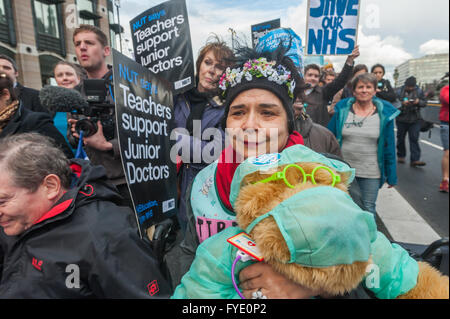 Londra, Regno Unito. Il 26 aprile, 2016. Un attivista NHS esercita un orso in scrub chirurgico da St Thomas' ospedale a Downing St in un giunto di marzo e rally organizzato dal dado e BMA alla fine della prima giornata della due giorni di sciopero da Junion medici. Leader laburista Jeremy Corbyn e cancelliere ombra John McDonnell erano sul davanti del marzo. Peter Marshall / Alamy Live News Foto Stock