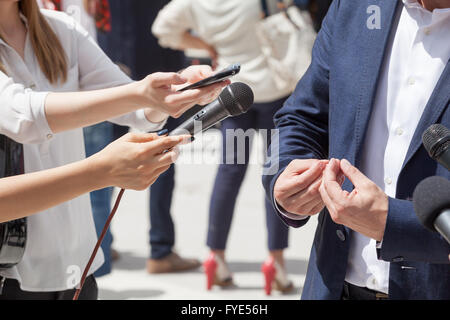 Reporters rendendo intervista con imprenditore o politico Foto Stock