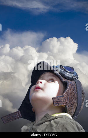 Un bambino vestito nel pilota guardando nel cielo blu Foto Stock