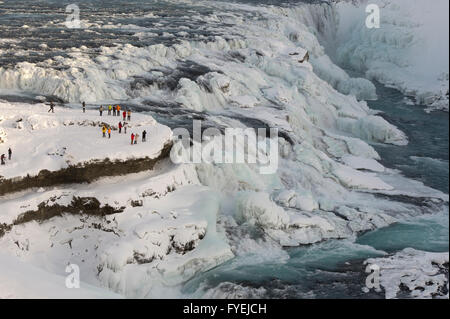 I turisti la visualizzazione delle spettacolari Cascate Gullfoss durante il periodo invernale in Islanda Foto Stock