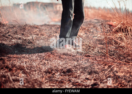 Le gambe della persona di spegnere un incendio. Foto Stock