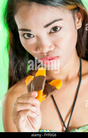 Slim giovane donna asiatica con mango barra di cioccolato Foto Stock