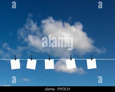 Post-it su una linea di abbigliamento isolata contro un cielo blu Foto Stock