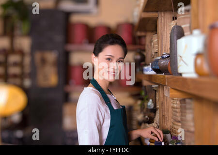Casa da tè proprietario disponendo ripiano Foto Stock