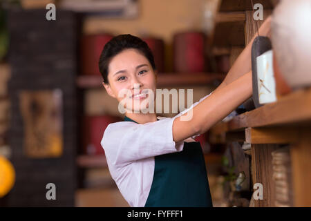 Casa da tè proprietario disponendo ripiano Foto Stock