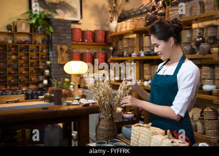 Casa da tè proprietario disponendo ripiano Foto Stock