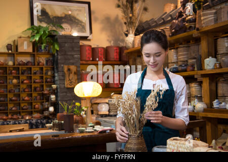 Casa da tè proprietario disponendo ripiano Foto Stock