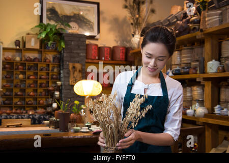 Casa da tè proprietario disponendo ripiano Foto Stock