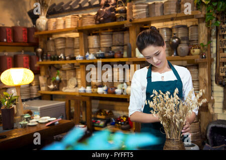 Casa da tè proprietario disponendo ripiano Foto Stock