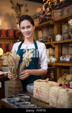 Casa da tè proprietario disponendo ripiano Foto Stock