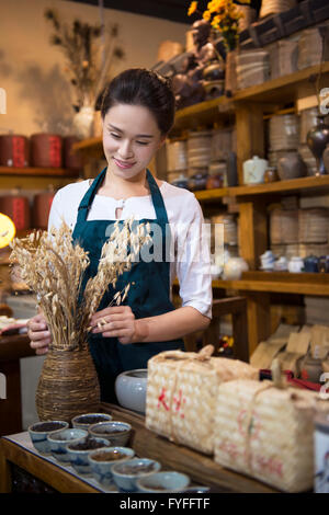 Casa da tè proprietario disponendo ripiano Foto Stock