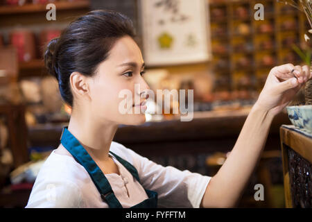 Casa da tè proprietario disponendo ripiano Foto Stock